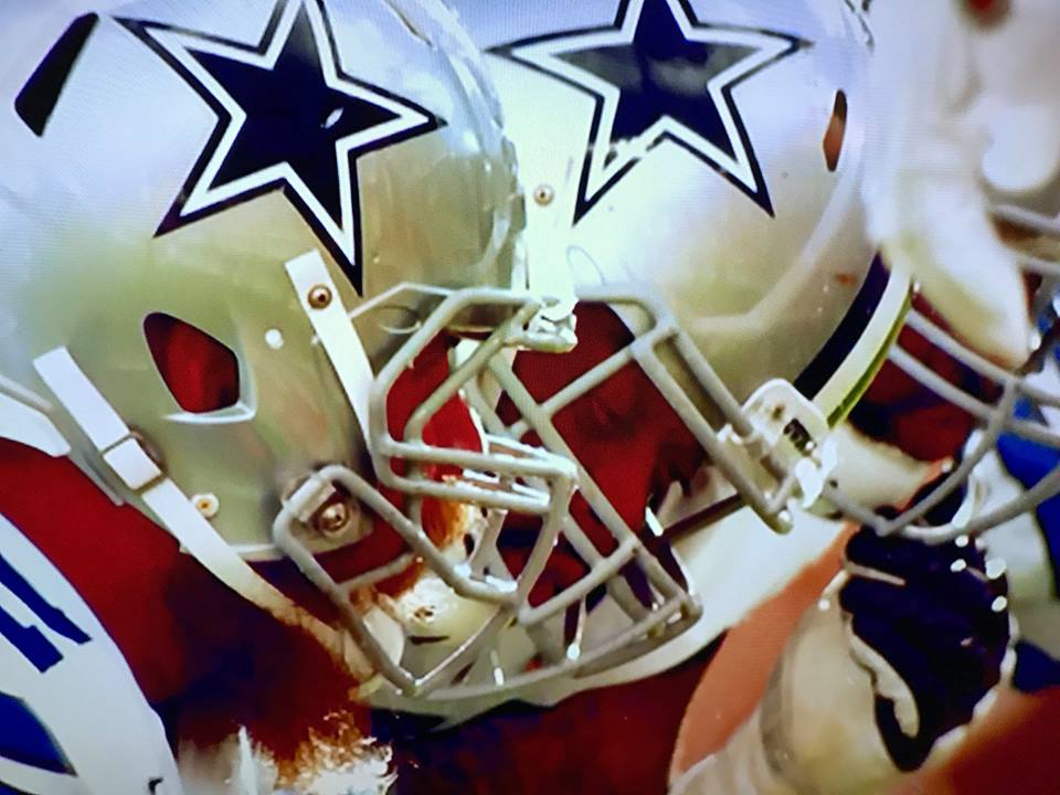 Close-up picture/screenshot of Dallas Cowboys players in huddle/on the line