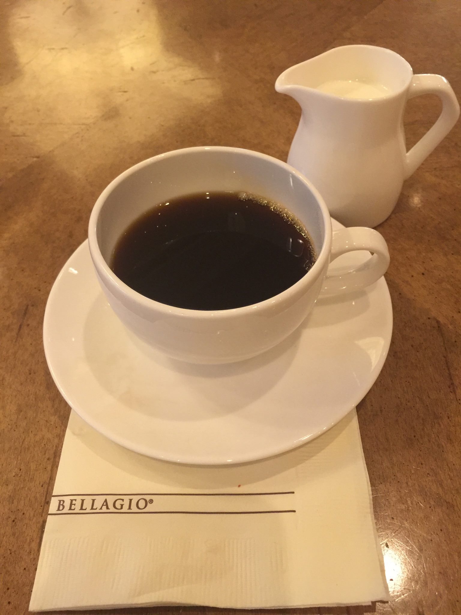 Picture of coffee-filled cup and saucer on top of Bellagio napkin